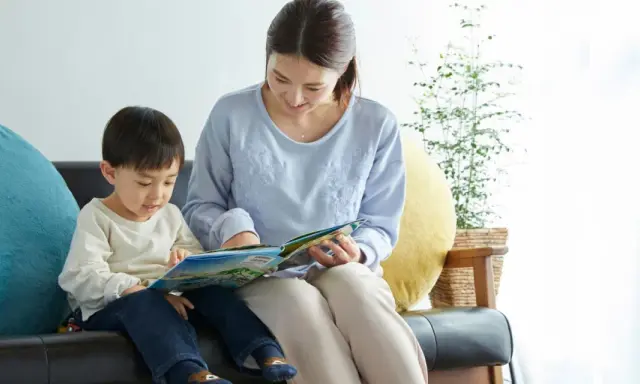 Madre e hijo comparten un momento de lectura, aprendiendo juntos. Las frases de disciplina pueden ser parte de las lecciones de vida que se transmiten.
