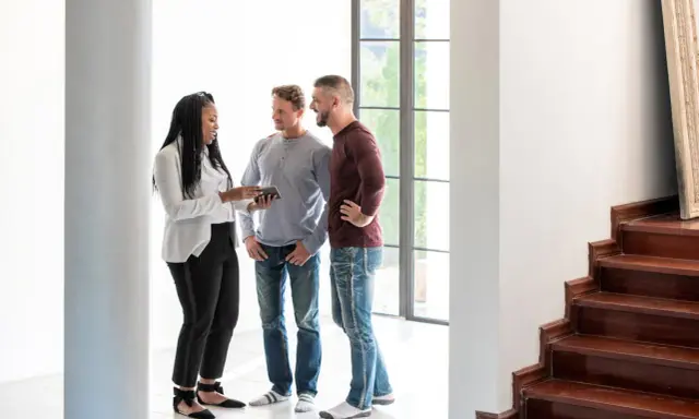 Un agent immobilier montre un appartement à un couple. La question se pose : peut-on louer un appartement seul quand on est marié ?