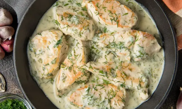 Pyszny kurczak w sosie śmietanowym z koperkiem, podany w żeliwnej patelni. Aromatyczny i kremowy.