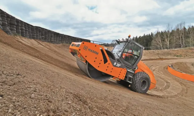 Rodillo Hamm H 20i trabajando en una pendiente, realizando la compactación del suelo.