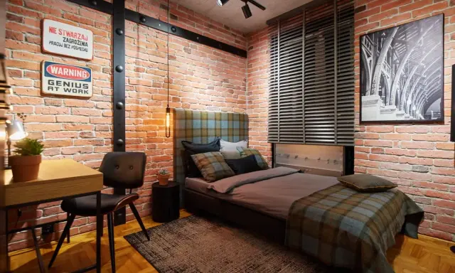 Aranżacje pokoju młodego mężczyzny w stylu loft. Czerwona cegła, metalowe belki i stylowe dodatki tworzą niepowtarzalny klimat.