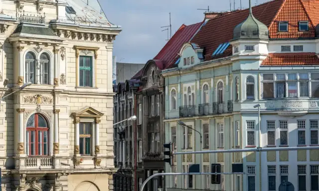 Kamienice na rynku w Bielsku-Białej, z bogatymi zdobieniami i różnorodnymi dachami, tworzą malowniczy widok.