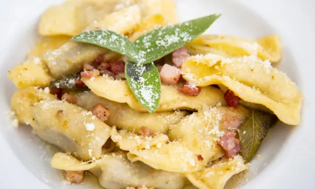 Ravioli fatti in casa con pancetta croccante, salvia e parmigiano, un assaggio dei piatti tipici bergamaschi.