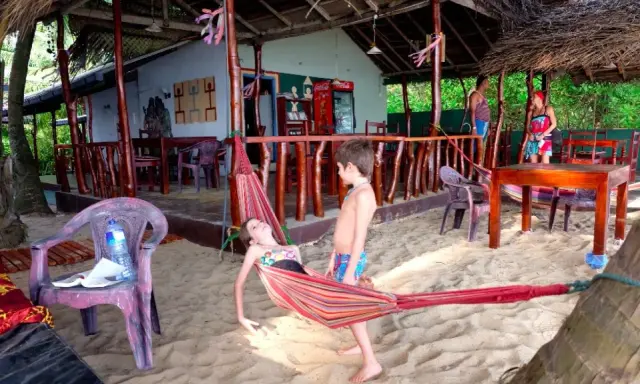 Niños disfrutan de una hamaca en una playa de Sri Lanka. Un paraíso tropical para familias.