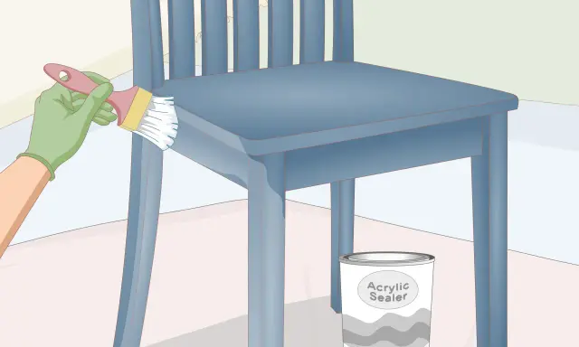 Pintando una silla de madera azul con un pincel. Un bote de sellador acrílico está al lado. Aprende como pintar sillas de madera estilo vintage.