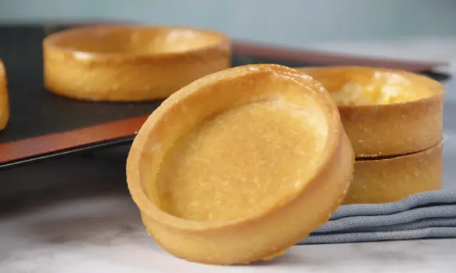 Fonds de tartelettes dorés, prêts pour une recette de pâte sucrée. Parfaits pour des desserts gourmands.
