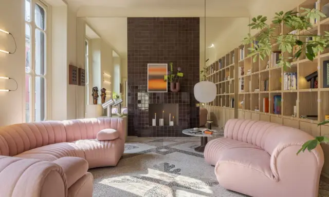 Divani rosa in un luminoso open space con camino moderno e libreria a parete. Case moderne interni open space.