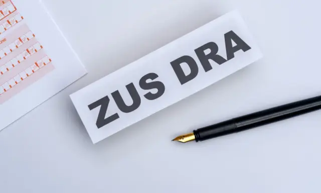 ZUS DRA na papierze, obok czarne pióro. Dokumenty do wypełnienia.