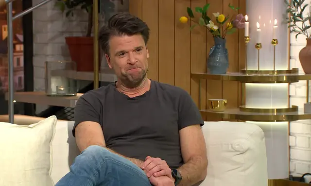Peter Magnusson sitter i en soffa, kanske redo att prata om sina filmer och tv-program.
