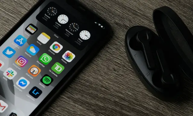 Chcesz wiedzieć, jak zaktualizować iPhone? Na ekranie widać ikony aplikacji, zegary i słuchawki.