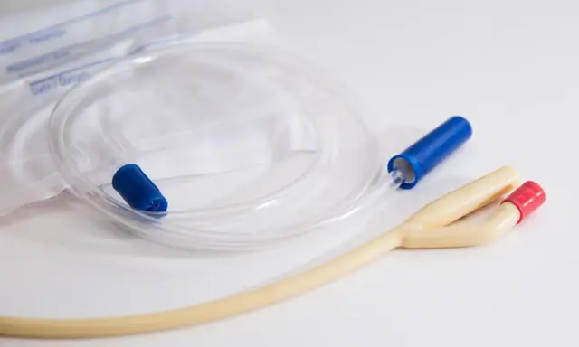 Cewnik hydrofilowy z niebieską i czerwoną końcówką, gotowy do użycia. Obok leży sterylne opakowanie.