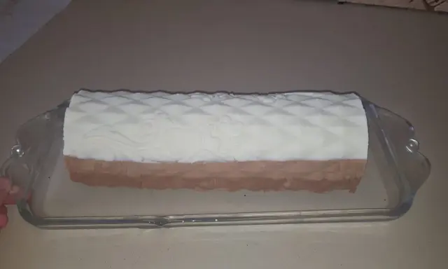 Un biscuit croustillant pour entremet, avec un décor en relief, est présenté dans un plat en verre.