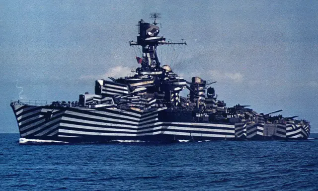 Un navire de guerre à l'impressionnant camouflage zébré, conçu pour tromper l'ennemi. Ce bateau militaire arbore un motif audacieux.