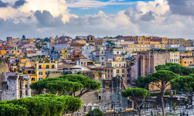 Vista panorámica de Roma con edificios históricos y pinos. Jóvenes exploran la ciudad eterna, disfrutando de su belleza.