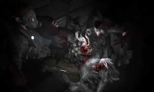 Postapokaliptyczna walka z potwornym królem szczurów w The Last of Us. Postać w masce gazowej i z latarką mierzy się z przerażającym stworzeniem.