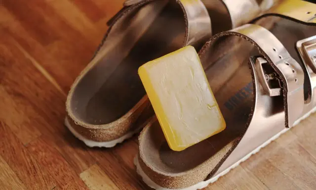 Kostka mydła obok sandałów Birkenstock, gotowa do czyszczenia.