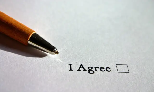 Długopis zbliża się do pola wyboru obok napisu "I Agree". To może być część testu B1 English.