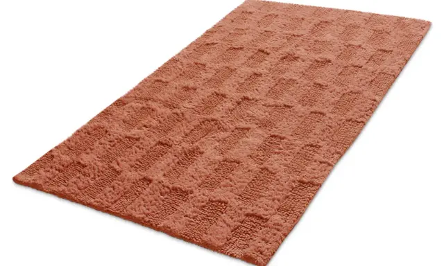 En mjuk, orange badrumsmatta med ett rutmönster. Den ger en varm och inbjudande känsla.