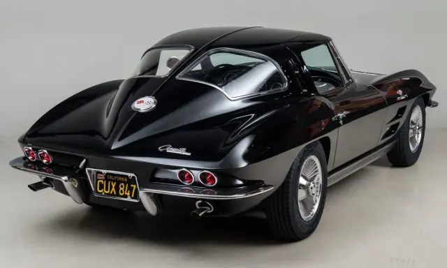 Un clásico Corvette Stingray negro, un ícono de los muscle cars americanos, con su distintiva silueta y detalles cromados.
