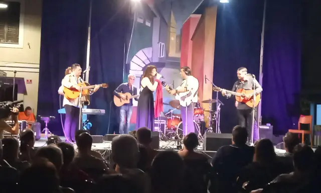 Concerto dal vivo con chitarre acustiche e voce, gli accordi di Bamboléo risuonano nell'aria.