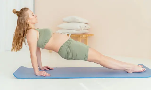 Gravid kvinna i yinyoga-position på matta, med fokus på lugn och styrka under graviditeten.