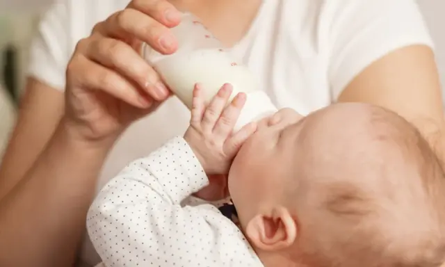 Dziecko pije mleko modyfikowane z butelki. Karmienie to może mieć różne konsekwencje dla rozwoju malucha.