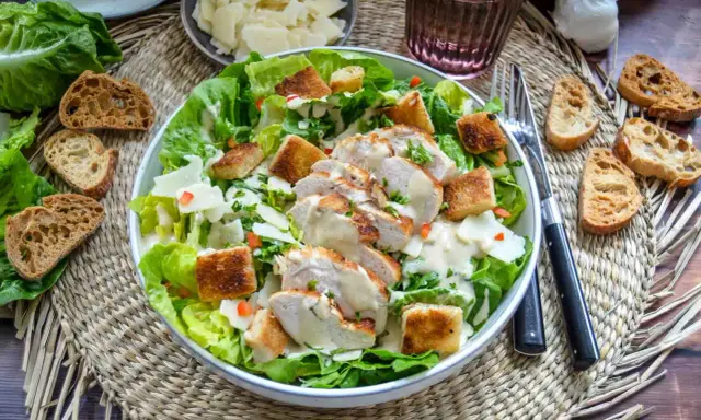 Saftiges Hähnchenbrustfilet auf knackigem Römersalat mit Croutons und cremiger Sauce – eine köstliche Caesar Salad.