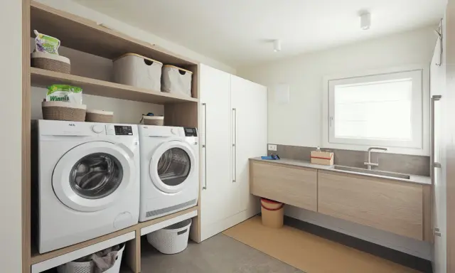Progetto bagno con lavanderia: lavatrice, asciugatrice, lavabo e armadi. Soluzione funzionale e moderna.