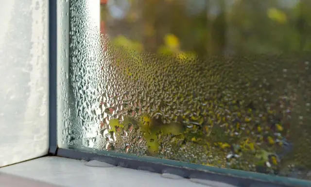 Condensación en marco ventana aluminio. El cristal empañado dificulta ver el exterior.