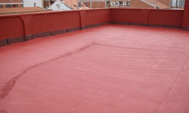 Tejado con acabado rojo, recién aplicado un slurry que es una capa protectora.