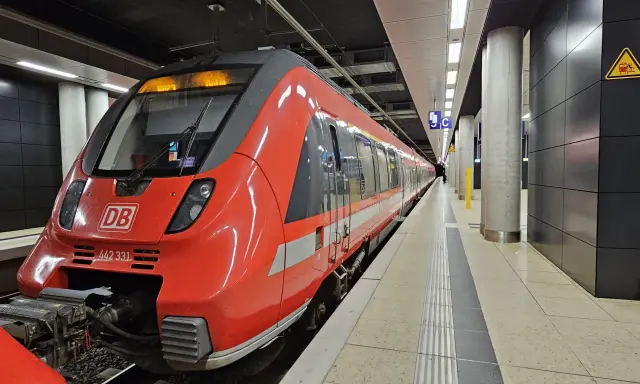 Röd DB-tåg på en station, redo att ta dig från berlin flygplats till centrum.
