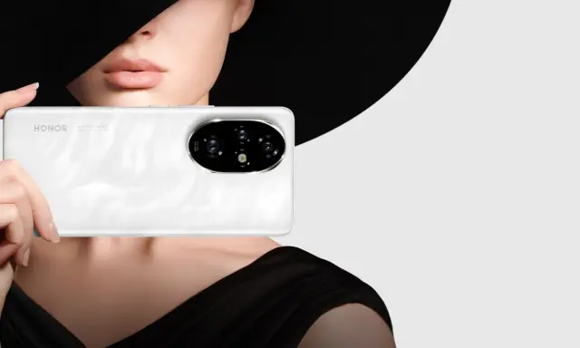 Primo piano di un telefono Honor bianco con un'elegante donna sullo sfondo, che evoca un effetto ritratto foto.
