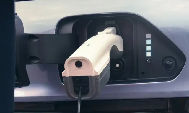Cargando un coche eléctrico. Aunque los coches eléctricos no tienen embrague, este se conecta a la red para recargar su energía.