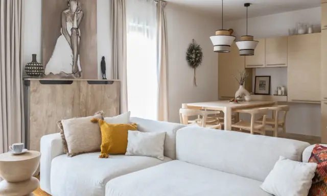 Jasny salon z sofą, stołem i krzesłami w stylu modern organic.