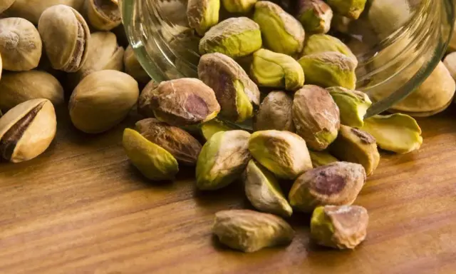 Garść pistacji wysypana ze słoika. Czy pistacje są kaloryczne? Tak, ale zdrowe!
