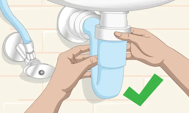 Manos ajustando el sifón azul del lavabo. Un símbolo de verificación verde indica que la tarea de cambiar sifón lavabo está completa.