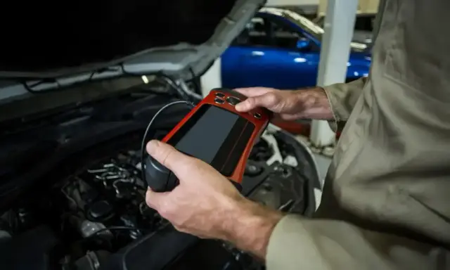 Mechanik używa skanera diagnostycznego do sprawdzenia stanu silnika. To ważne, by mieć aktualne papiery od gazu do przeglądu.