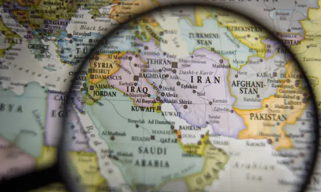 Mapa świata pod lupą, widoczne kraje Bliskiego Wschodu i Azji Południowej. W centrum Iran, Irak, Arabia Saudyjska.