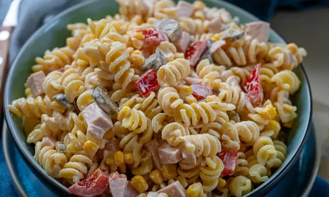 Schüssel mit cremigem, schneller Nudelsalat, gefüllt mit Spiralnudeln, Schinkenwürfeln, Mais und Paprika. Perfekt für ein schnelles Mittagessen.
