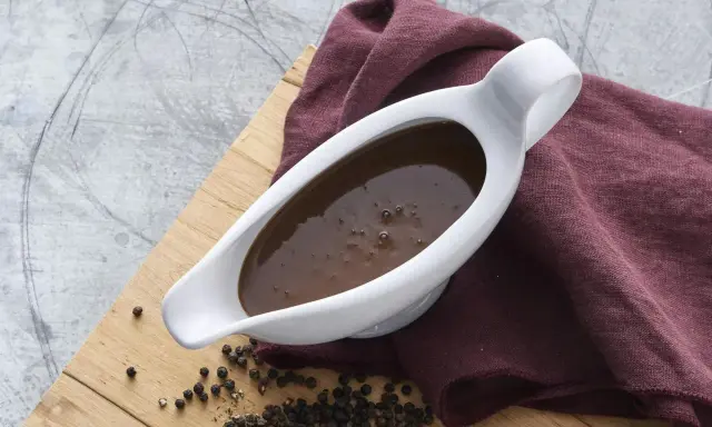 En vit såsslev fylld med mustig brunsås, redo att förhöja din middag. Ett perfekt brunsås recept för alla tillfällen.