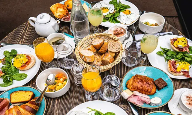 Un festin parisien : œufs Bénédicte, croissants, jus d'orange et café. Une spécialité parisienne pour un brunch gourmand.