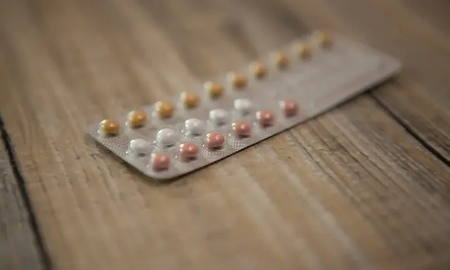 Blister opakowania tabletek antykoncepcyjnych na drewnianym tle. Zastanawiasz się nad tabletki antykoncepcyjne skutki uboczne?