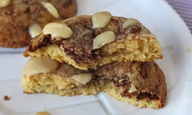 Biscotti alla cannella con gocce di cioccolato e mandorle, uno spezzato mostra l'interno morbido e profumato.