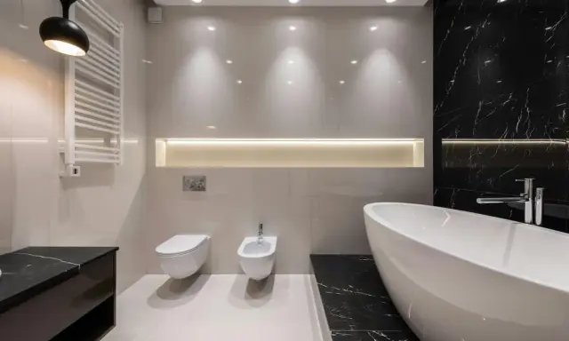 Radiador toallero blanco colgado en pared junto a un inodoro y bidet, ideal para baños modernos.