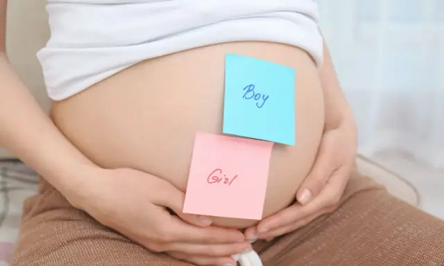 Brzuszek ciężarnej z karteczkami "Boy" i "Girl". Czy płeć dziecka może się zmienić?