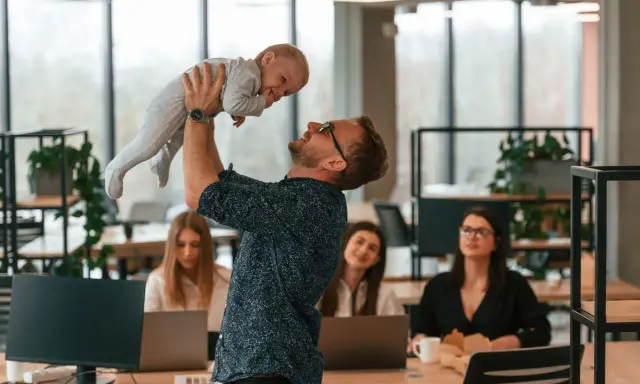 Szczęśliwy ojciec podrzuca dziecko w biurze, gdzie pracują kobiety. Czy urlop wychowawczy wlicza się do stażu pracy?