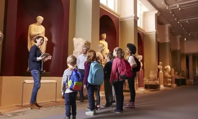 Un grupo de niños disfruta de las exposiciones en un museo de Madrid, aprendiendo sobre arte e historia con su guía.