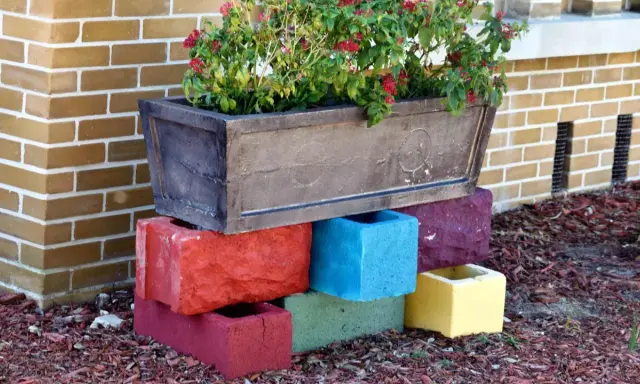 Un bac à fleurs sur des blocs de béton colorés, une idée de **diy jardin** pour rehausser vos plantes.