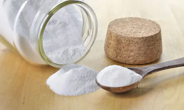 Bicarbonate de soude, une solution naturelle pour le traitement de l'oïdium. Une cuillère en bois et un pot renversé en témoignent.