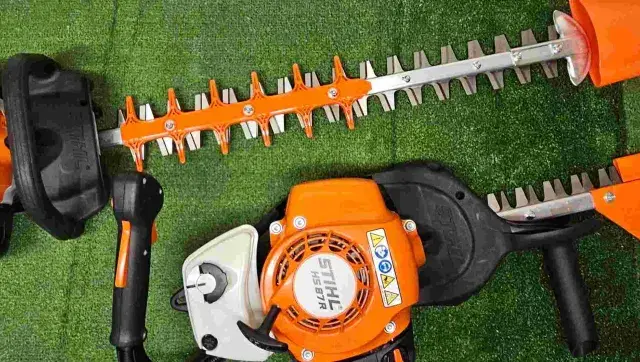 Deux taille-haies Stihl orange et noirs, prêts pour le taillage de haie.